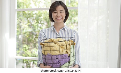 Young Asian Woman Carrying Laundry Basket