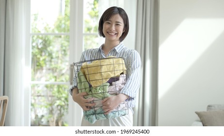 Young Asian Woman Carrying Laundry Basket