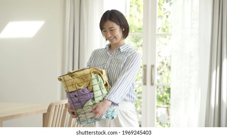 Young Asian Woman Carrying Laundry Basket