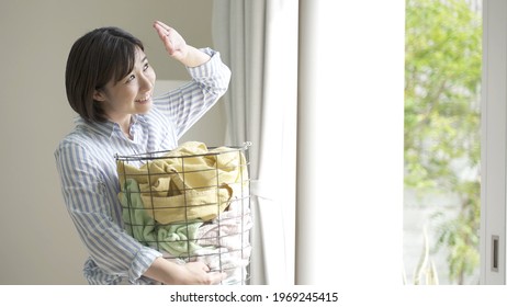 Young Asian Woman Carrying Laundry Basket