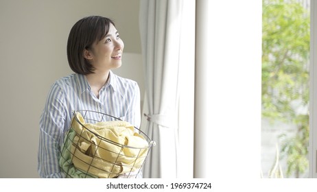 Young Asian Woman Carrying Laundry Basket