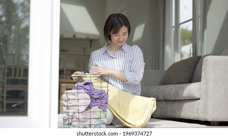 Young Asian Woman Carrying Laundry Basket