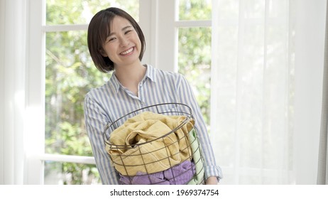 Young Asian Woman Carrying Laundry Basket