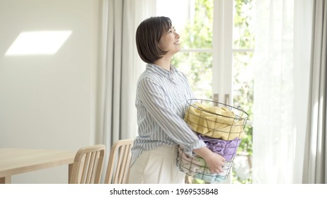 Young Asian Woman Carrying Laundry Basket