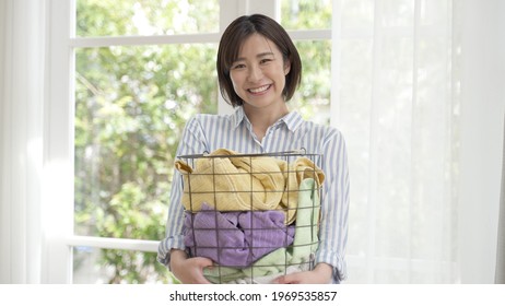 Young Asian Woman Carrying Laundry Basket