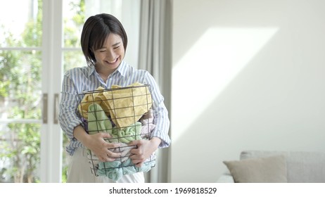 Young Asian Woman Carrying Laundry Basket