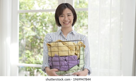 Young Asian Woman Carrying Laundry Basket