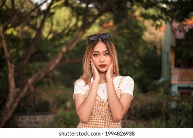 A young asian woman in casual summer wear at the park during the afternoon. Wearing blue gray contact lens - Shutterstock ID 1994826938