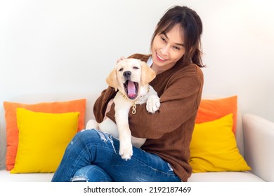 Young Asian Woman Cheerful And Relax Time With Sweet Puppy Dog Pet And Owner Having Good Time Together At Living Room At Home. Female Drinking Coffee With Pet Friendship.  Lifestyle Concept