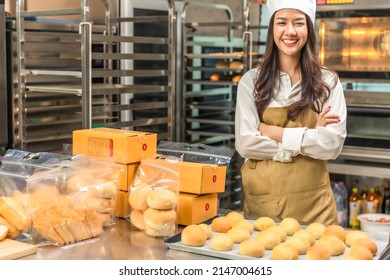 Young Asian woman chef startup partners, small business blogger live mobile application technology, bakery sales online promotion. at kitchen.Chef looking at the phone camera. - Powered by Shutterstock