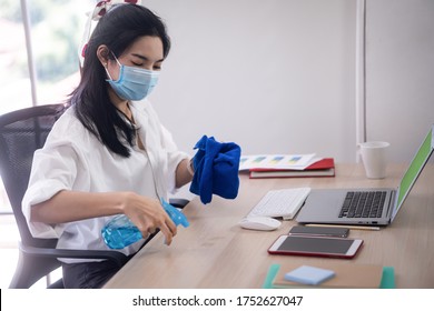 Young Asian Woman Cleaning Her Computer Desk And Equipment To Protect Covid19 Virus Infection