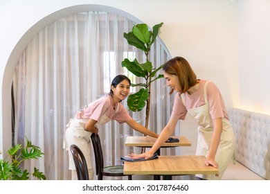 Young Asian woman coffee shop barista cleaning cafe before opening. Female waitress preparing bistro restaurant for service to customer. Small business owner and part time job working employee concept - Powered by Shutterstock