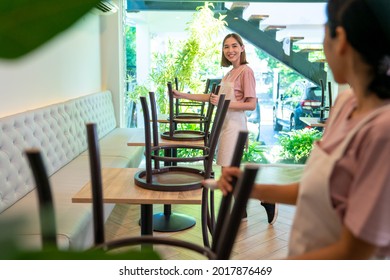 Young Asian woman coffee shop barista cleaning cafe before opening. Female waitress preparing bistro restaurant for service to customer. Small business owner and part time job working employee concept - Powered by Shutterstock