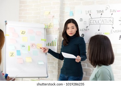 Young Asian Woman College Teacher Teaching Her Students In Classroom