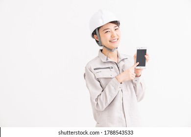 Young asian woman construction Worker  and white safety helmet,smart phone