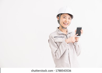Young asian woman construction Worker  and white safety helmet,smart phone