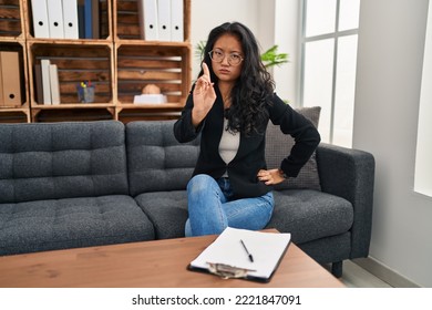 Young Asian Woman At Consultation Office Pointing With Finger Up And Angry Expression, Showing No Gesture 