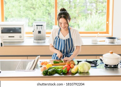 Young Asian Woman Cooking In The Kitchen.