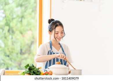 Young Asian Woman Cooking In The Kitchen.