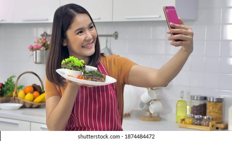 Young Asian Woman Cooking In Kitchen At Home.