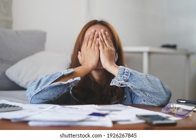 young asian woman cover her face after stressed with monthly bill expenses and credit card debt.