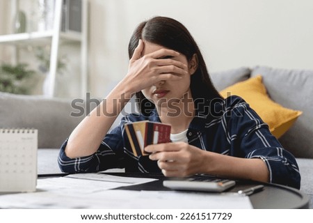 young asian woman cover her face after stressed with monthly bill expenses and credit card debt.