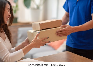 Young Asian Woman Customer Feeling Happy When Receiving Package From Delivery Service Company Staff.