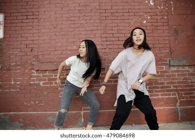 Young Asian Woman Dancing In City Street