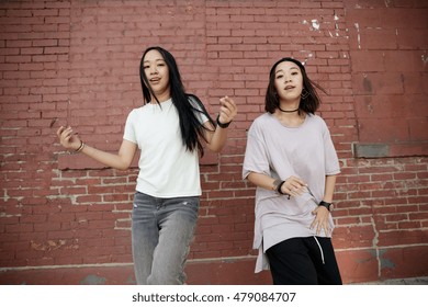 Young Asian Woman Dancing In City Street