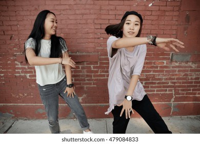 Young Asian Woman Dancing In City Street