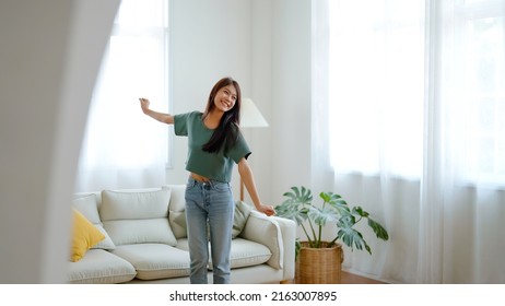 Young Asian Woman Dancing On The Floor In Living Room At Home. Happy Asia Female Smile Relaxing In House, Healthy Mental Wellness And Wellbeing