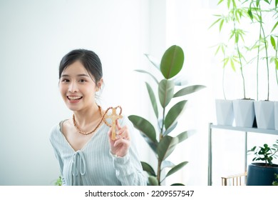 A Young Asian Woman With Depicted Wearing A Cross Necklace In Contemporary Fashion.