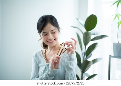 A Young Asian Woman With Depicted Wearing A Cross Necklace In Contemporary Fashion.