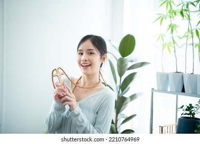 A Young Asian Woman With Depicted Wearing A Cross Necklace In Contemporary Fashion.