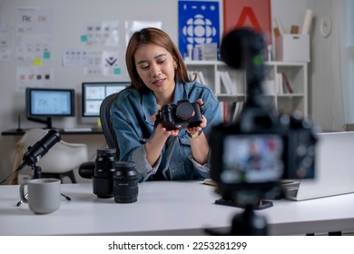 Young Asian woman designer, photographer blogger influencer filming teaching camera tutorial while looking at camera shooting education tutorial vlog training filming video course for social media. - Powered by Shutterstock