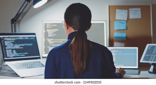 Young Asian Woman, Developer Programmer, Software Engineer, IT Support, Wearing Glasses Working Hard At Nitght Overtime On Computer To Check Coding In Bugging System. Back View