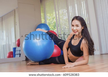 Young asian woman doing exercises with fitness ball.