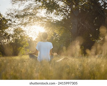 Young asian woman doing meditation in morning or evening at park, healthy woman relaxing and practicing yoga at city park. Mindfulness, destress, Healthy habits and balance concept - Powered by Shutterstock