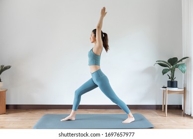 A Young Asian Woman Doing Yoga At Home