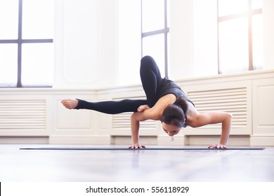 Young Asian Woman Doing Yoga Pose And Asana Ashtavakrasana. Fitness Girl Enjoying Yoga Indoors In Sport Clothes, Working Out In Gym Class