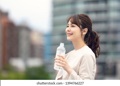 Young Asian Woman Drinking A Bottle Of Water. Hydration Concept.