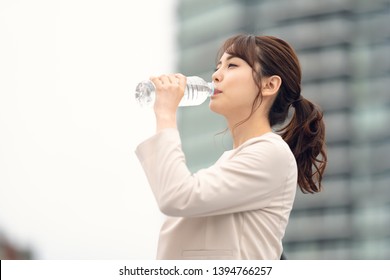 Young Asian Woman Drinking A Bottle Of Water. Hydration Concept.