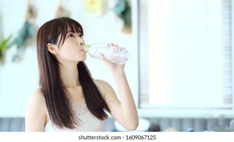 Young Asian Woman Drinking A Bottle Of Water. Hydration Concept.