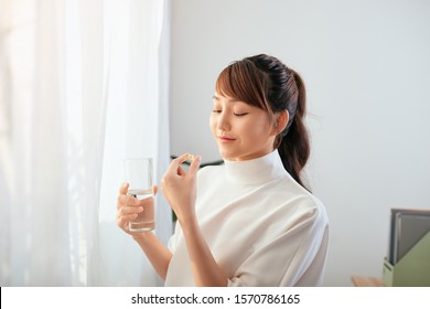 Young Asian Woman Drinking Medicine With Water Glass.