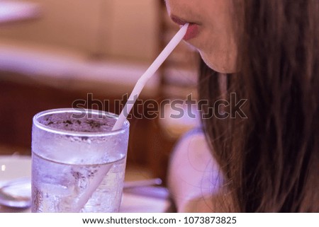 Young asian woman drinking pure water with straw.