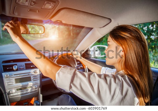 Young asian woman driver adjusting her rearview
mirror in the car