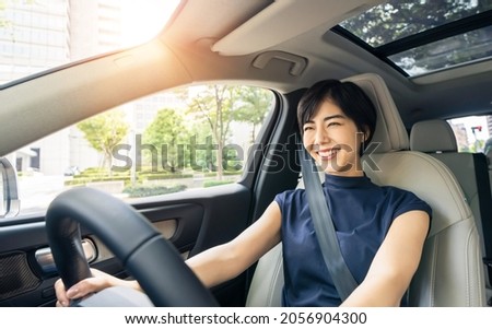Young asian woman driving a car.