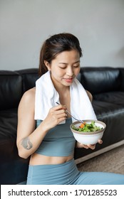 A Young Asian Woman Eating A Healthy Vegetable Salad In The Livi