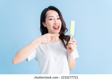 Young Asian Woman Eating Ice Cream On Background