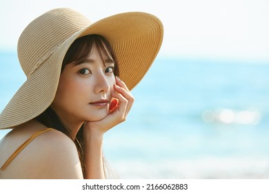 Young Asian Woman Enjoying The Resort On The Beach